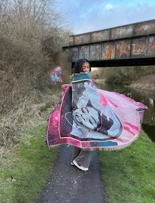 Portrait tapestry featuring a serene Black woman in shades of grey, pink, and teal. Shop unique art tapestries.